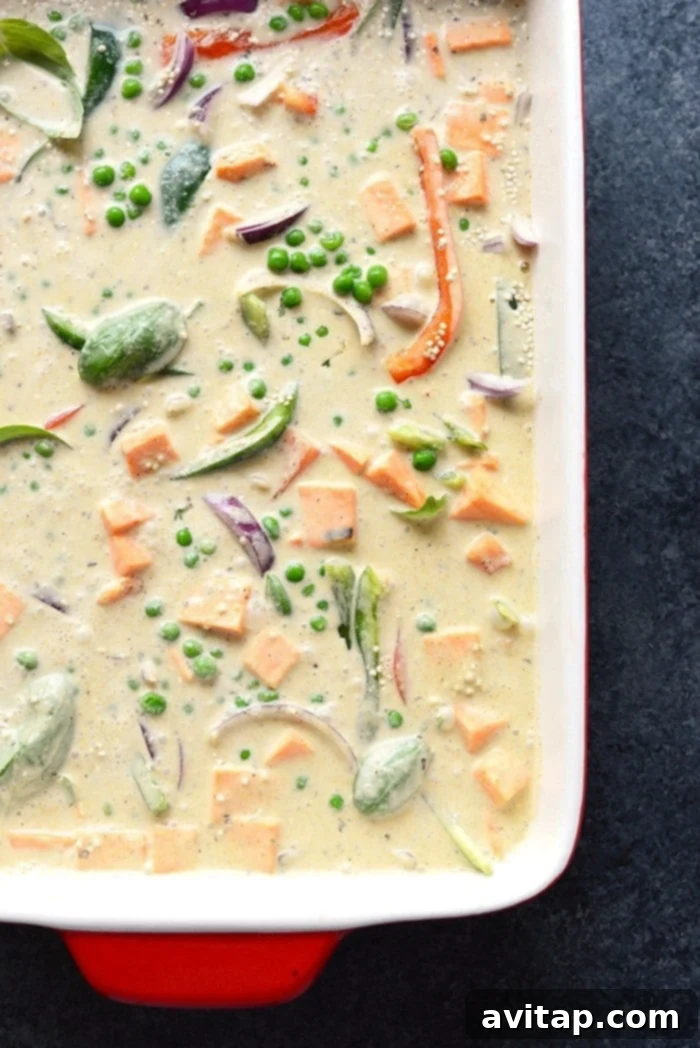 The Sweet Potato Green Curry Quinoa Casserole, freshly baked and steaming, with a spoon ready to scoop, highlighting its inviting warmth and readiness to serve.