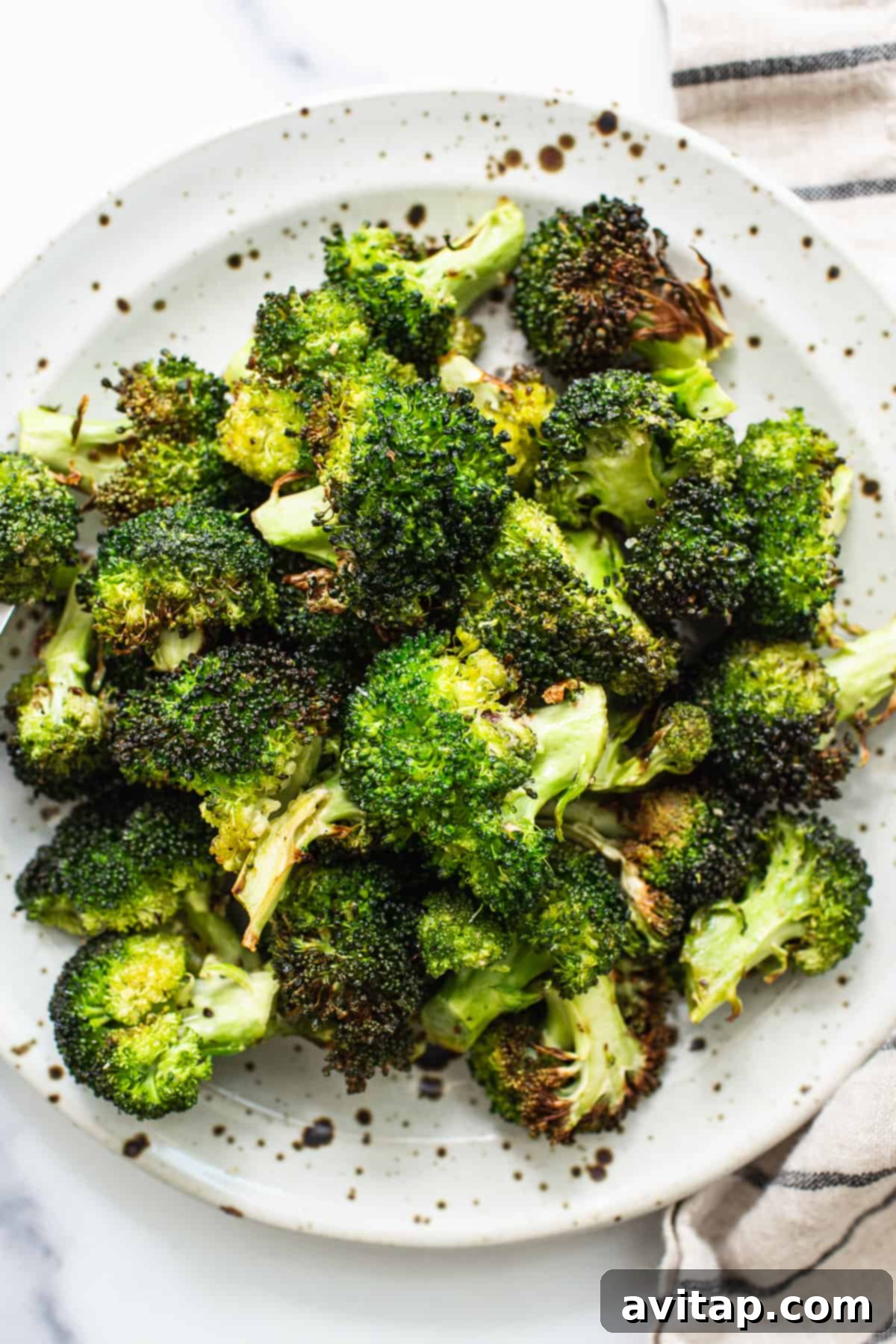 Crispy air fryer broccoli served on a plate, ready to eat.