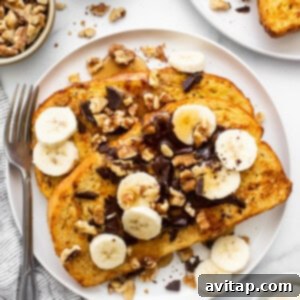 A plate of french toast with bananas, nuts and chocolate.