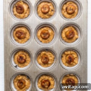 Decadent Bananas Foster Muffins 9 Muffin batter scooped into a lined muffin tin, topped with caramelized banana slices.