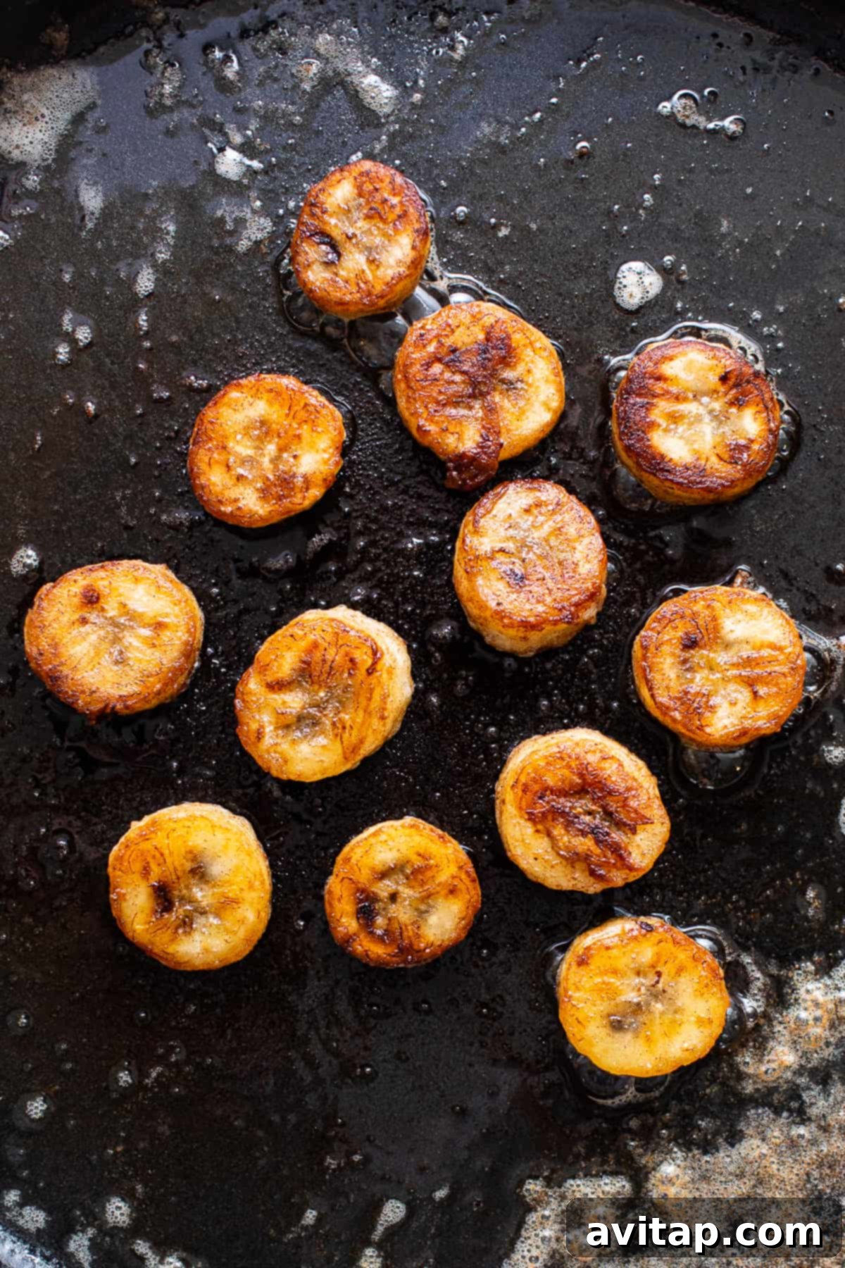 Creating the Perfect Caramelized Banana Topping Caramelizing banana slices in a skillet with butter and rum for the Bananas Foster topping.