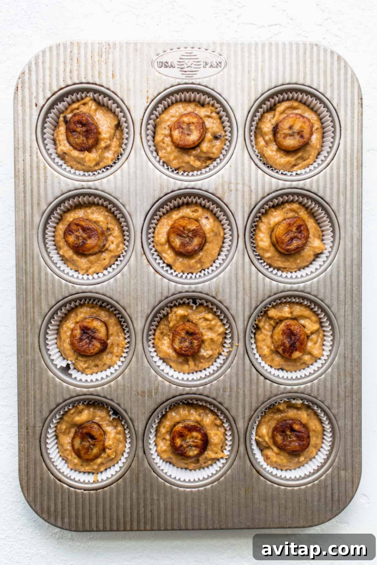 Decadent Bananas Foster Muffins 4 A tray of freshly baked Bananas Foster Muffins on a cooling rack, showcasing their delicious golden-brown tops.