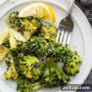 A plate of perfectly roasted broccoli, garnished and ready to eat.
