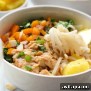 Island Chicken Noodle Feast 5 A vibrant bowl of Hawaiian chicken noodle soup with shredded chicken, carrots, and pineapple chunks.