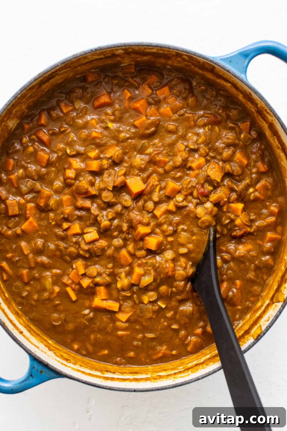 Lentil curry simmering in a Dutch oven. Vegetarian lentil curry in a dutch oven.