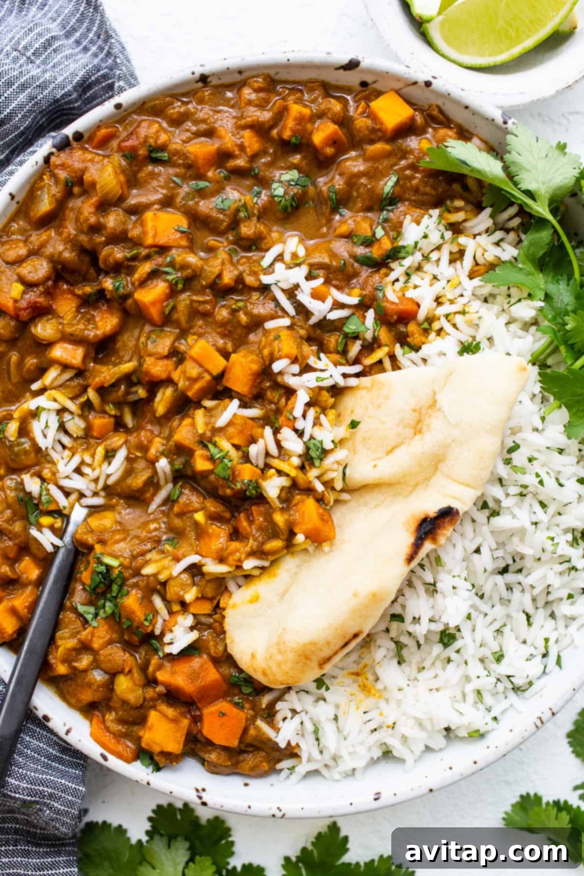 Lentil curry served with naan. Vegetarian lentil curry in a bowl with a slice of naan.