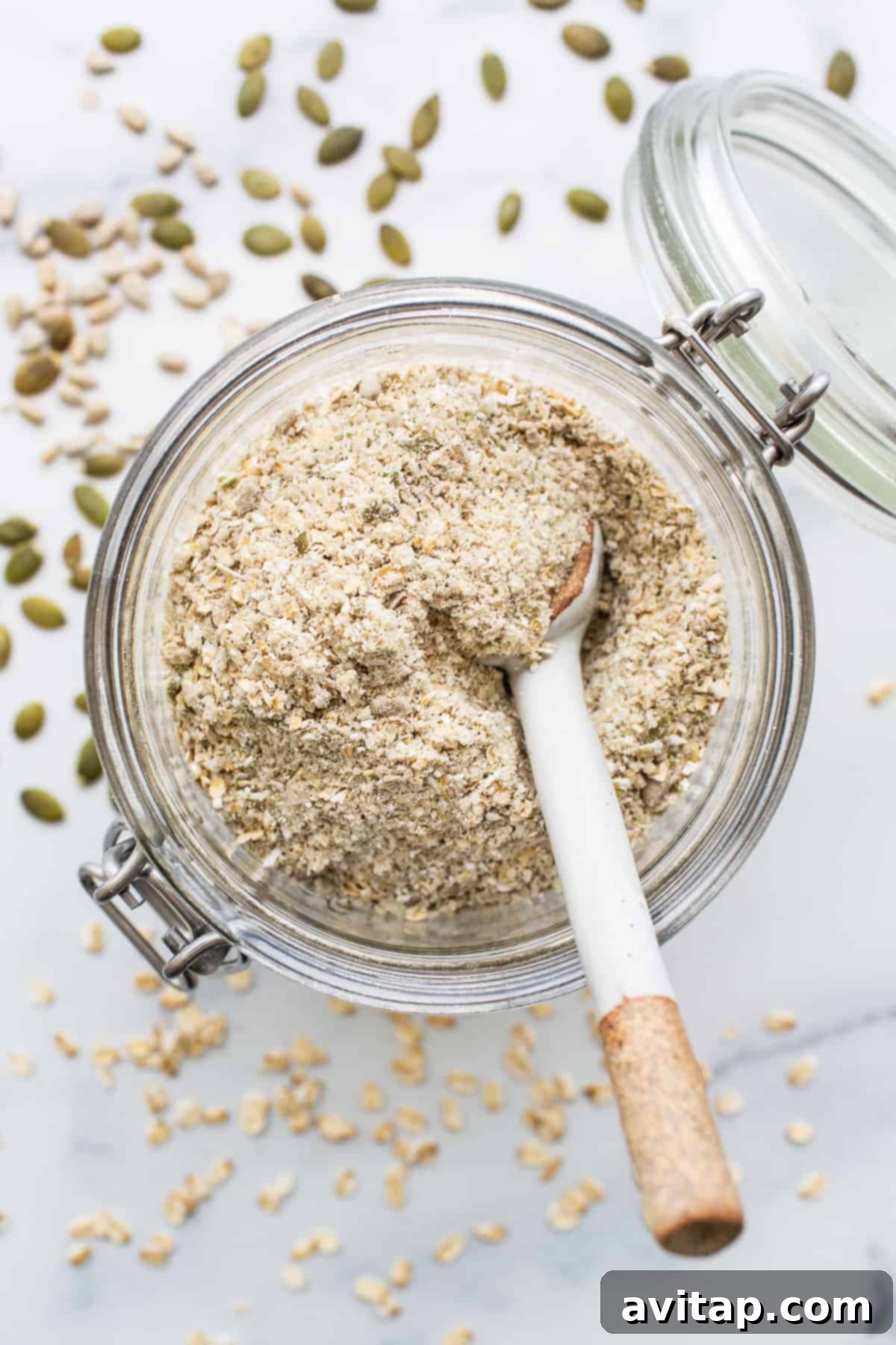 A glass jar filled with the dry porridge mix, showcasing the blend of oats, seeds, and spices.