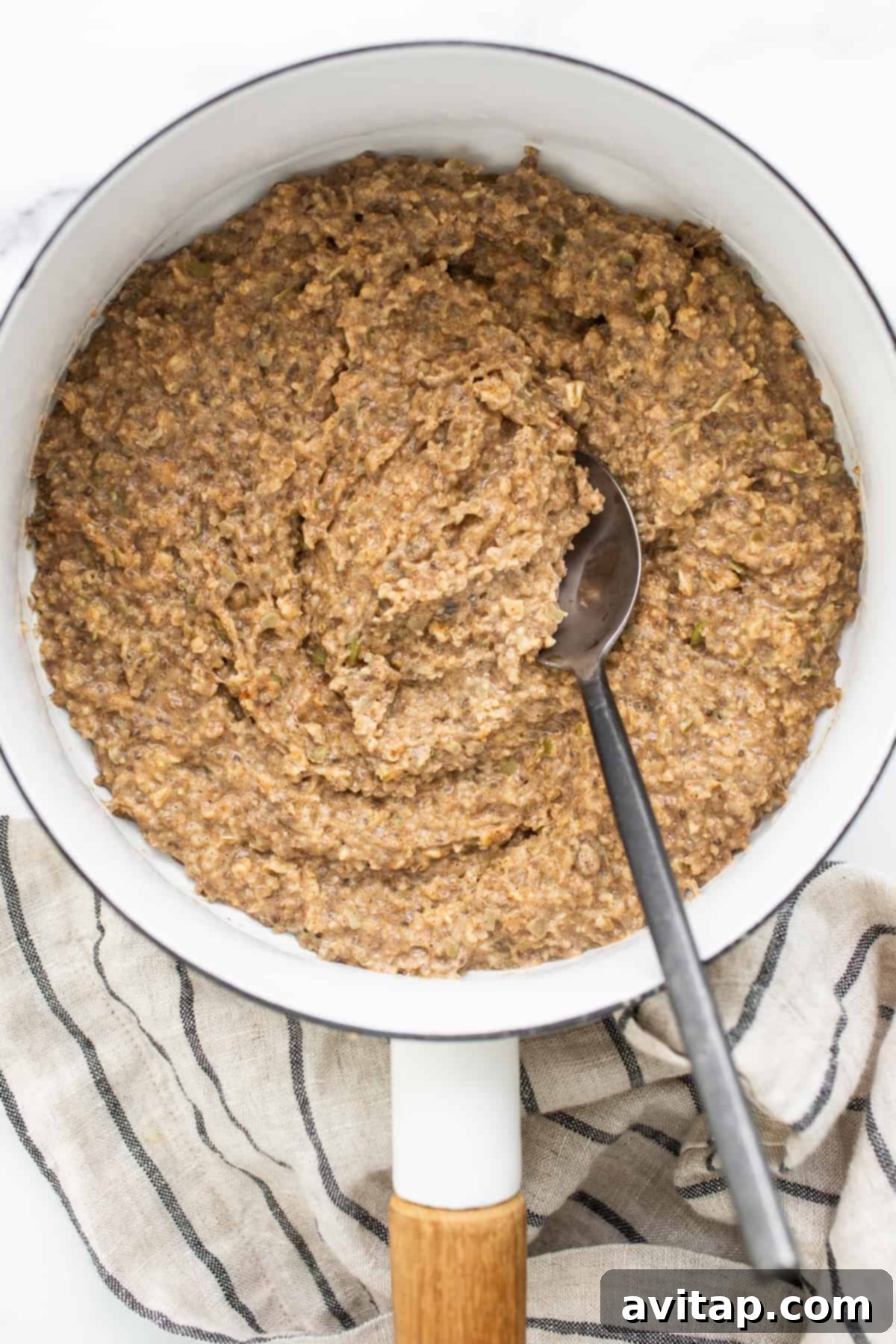 Creamy porridge simmering gently in a saucepan on the stovetop, releasing steam.