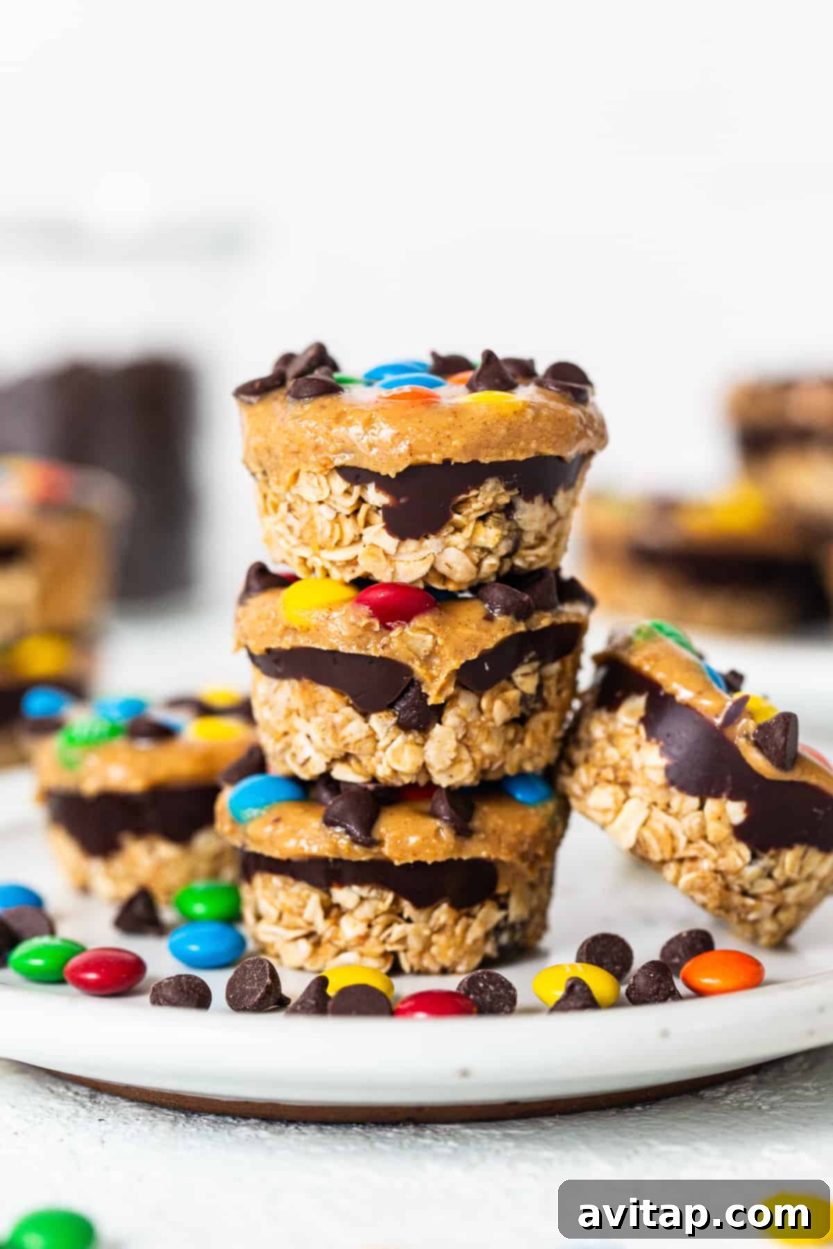 Monster cookie oat cups stacked on top of each other, showcasing their layers and colorful toppings.