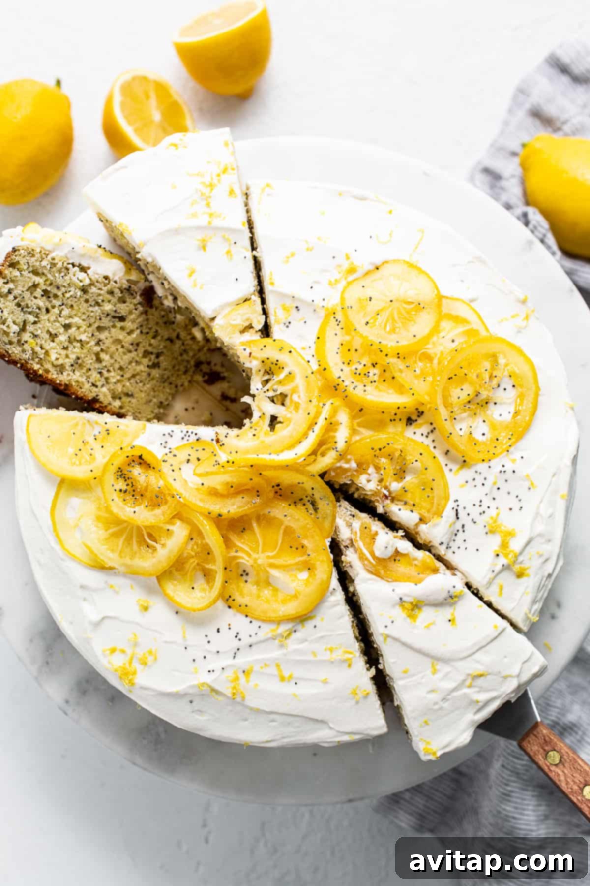 A beautifully presented lemon poppy seed cake. Lemon poppy seed cake on a white cake plate, ready to be served.