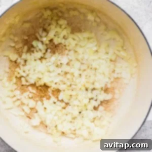 A pan with onions and garlic in it, ready for sautéing.
