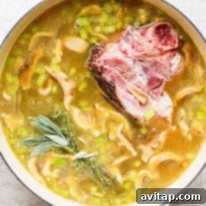 A pot of soup with meat, peas, and sprigs of rosemary (thyme/sage).