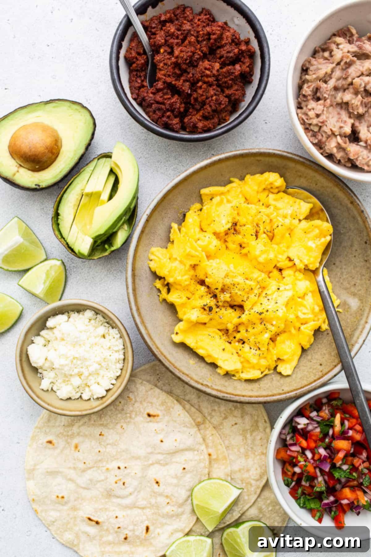 Fresh ingredients laid out for breakfast tacos, including tortillas, eggs, chorizo, and pico de gallo components.