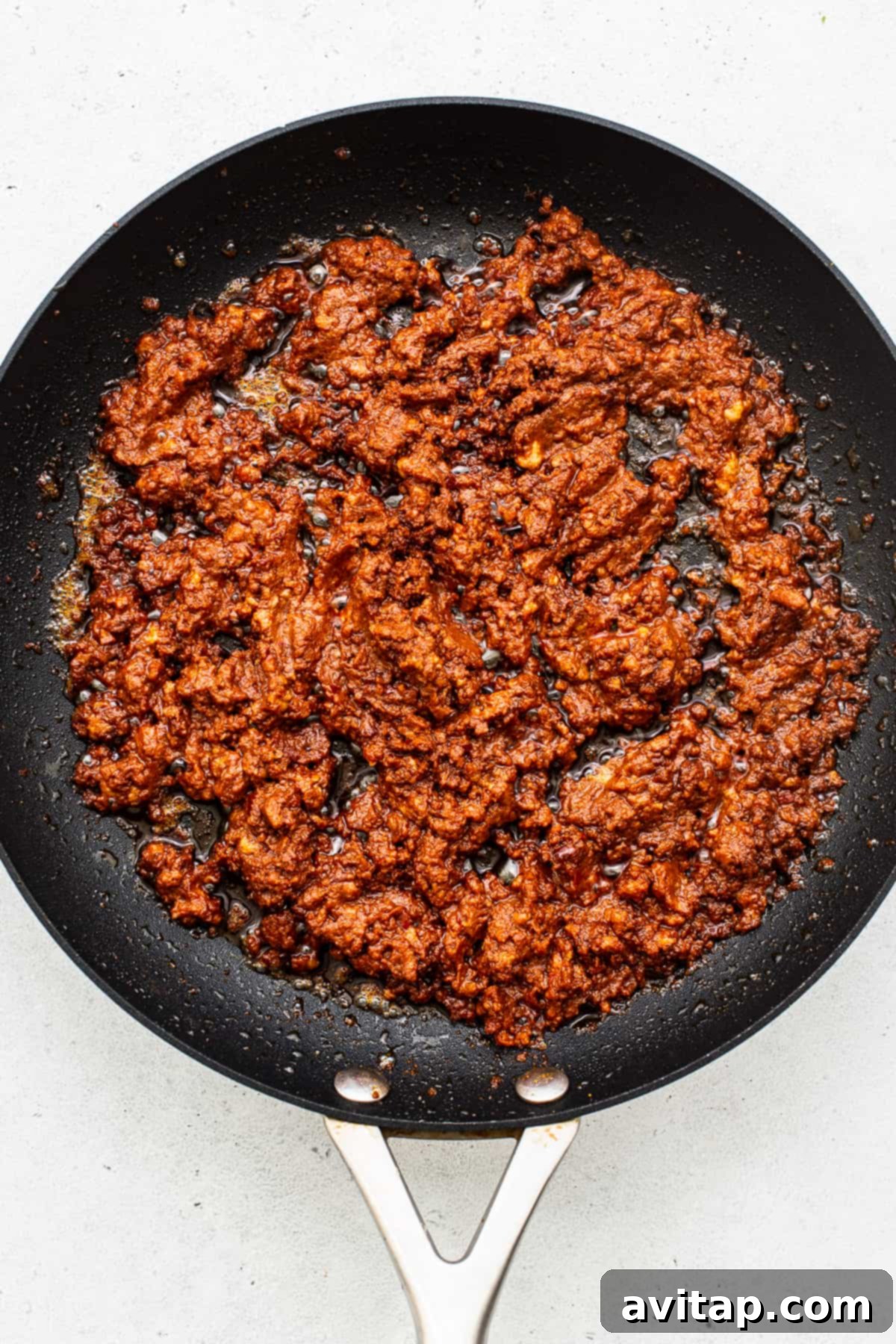 Crumbled breakfast chorizo cooking in a skillet, ready for assembly into tacos.
