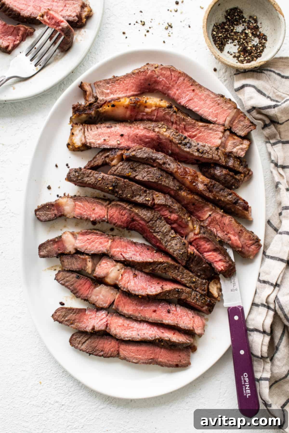 Perfectly sliced air fryer steak on a plate, showcasing its succulent, pink interior and crispy crust.