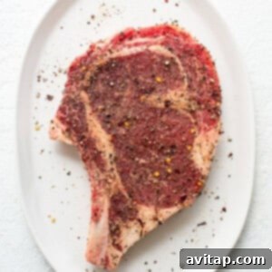 A seasoned piece of steak on a white plate, ready for air frying.