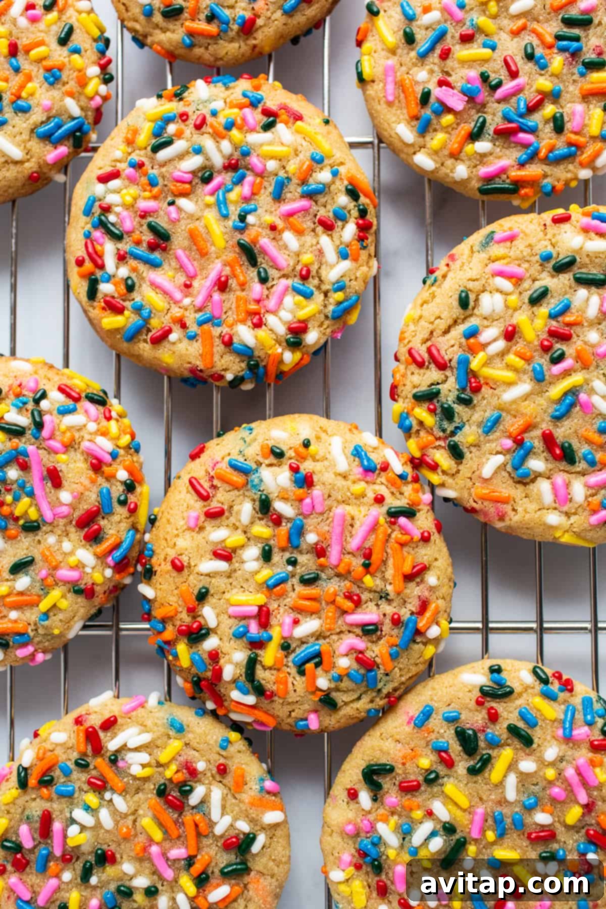 Colorful masa cookies cooling on a wire rack, showcasing their vibrant rainbow sprinkles.