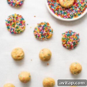 Masa cookie dough balls covered in rainbow sprinkles on a baking sheet.