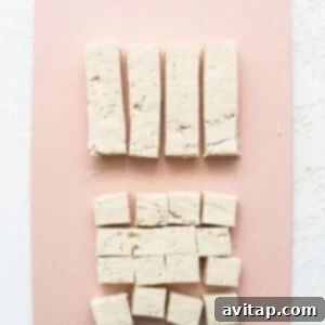 Tofu cubes on a pink cutting board.