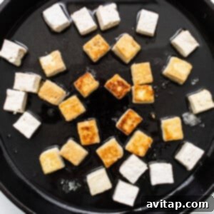 Tofu in a skillet on a white surface.