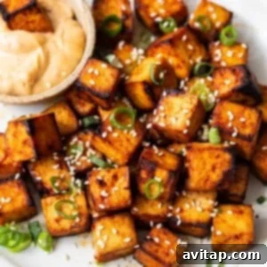 Air fryer tofu on a plate with dipping sauce.