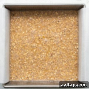 Oatmeal bars in a baking pan on a white surface, just baked and cooling.