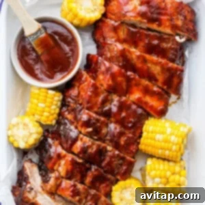 bbq ribs and corn on the cob with bbq sauce.