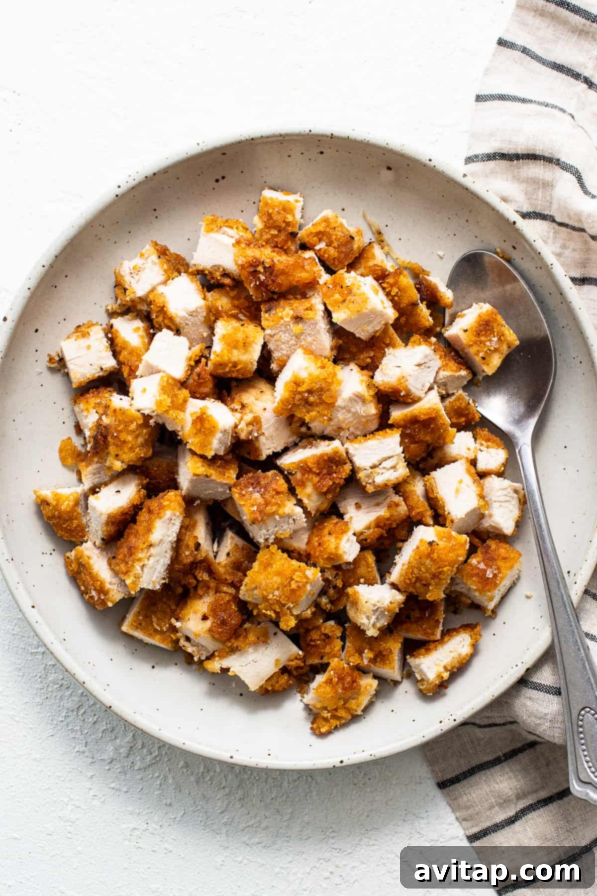 A serving of crispy chicken salad with a fork, ready to be enjoyed.