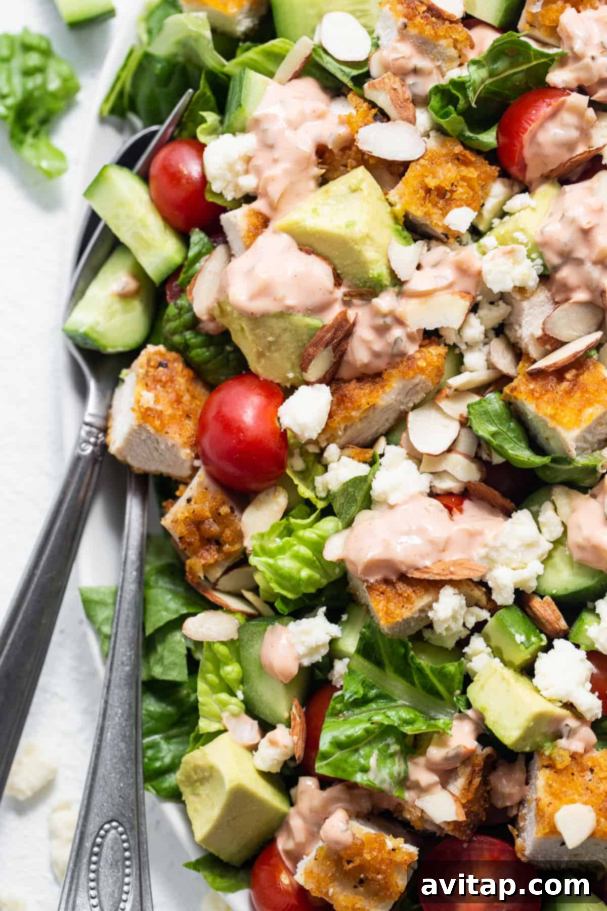 A generously sized crispy chicken salad with all components perfectly mixed and dressed.