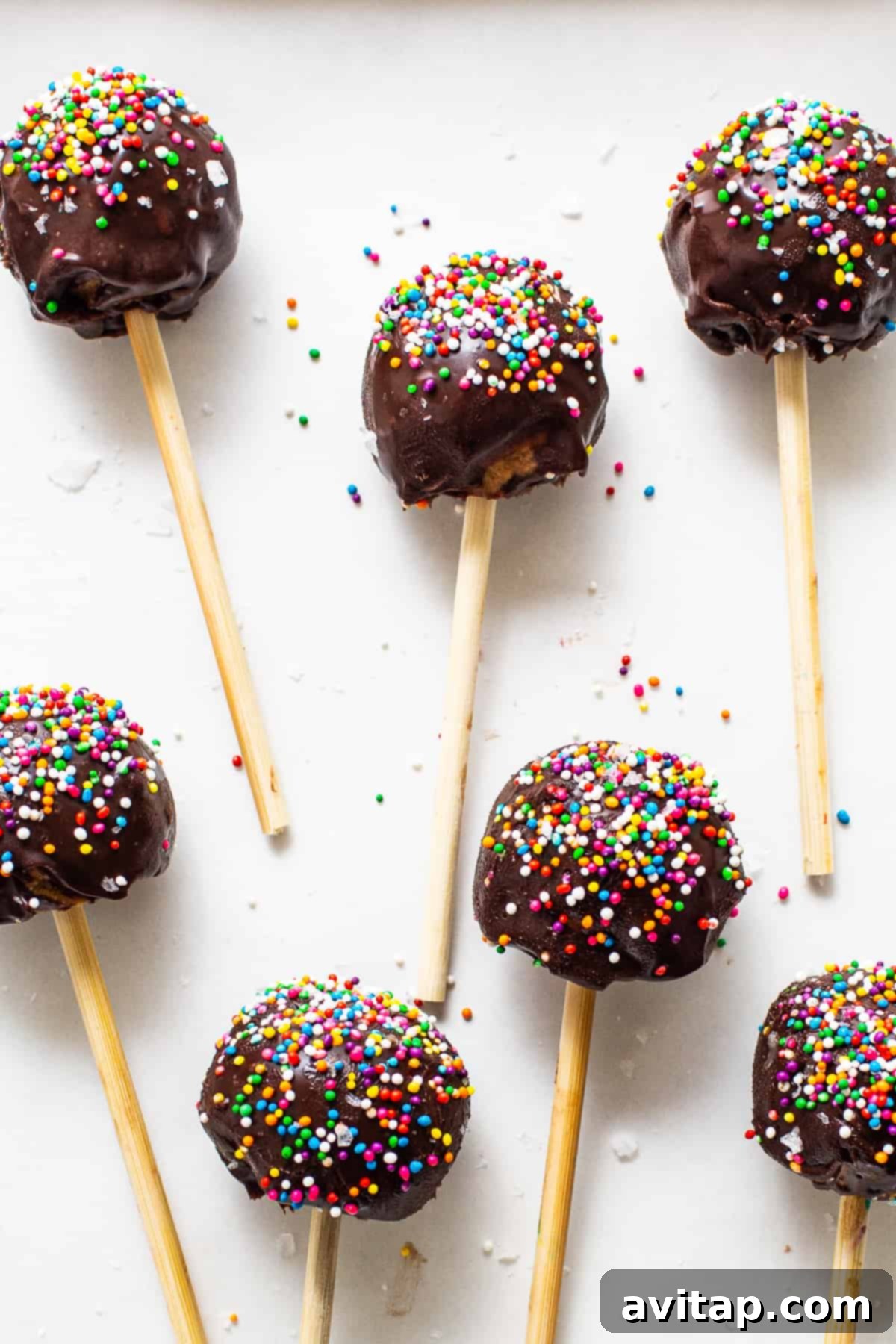 Protein cake pops covered in colorful sprinkles, arranged neatly.