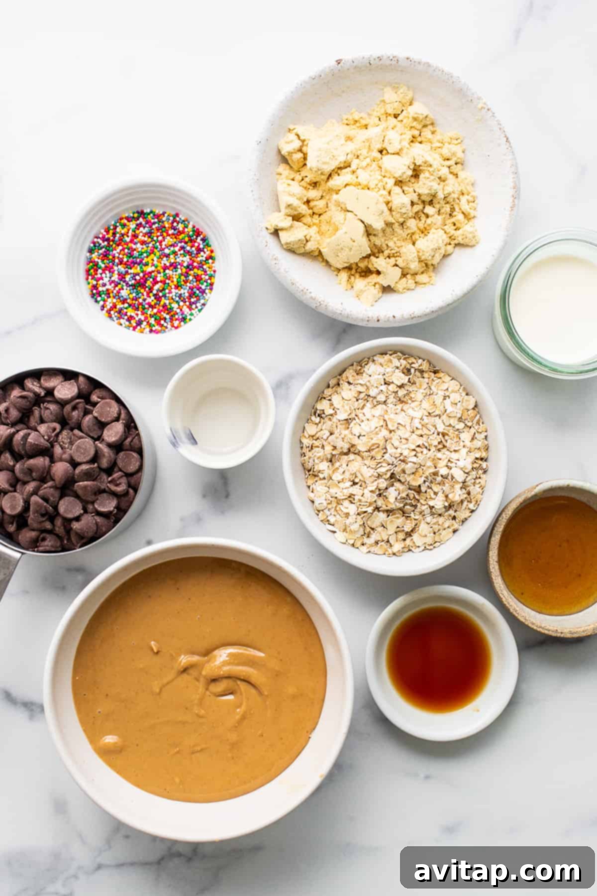 Bowls of ingredients including cashew butter, oats, protein powder, and chocolate chips for protein cake pops.