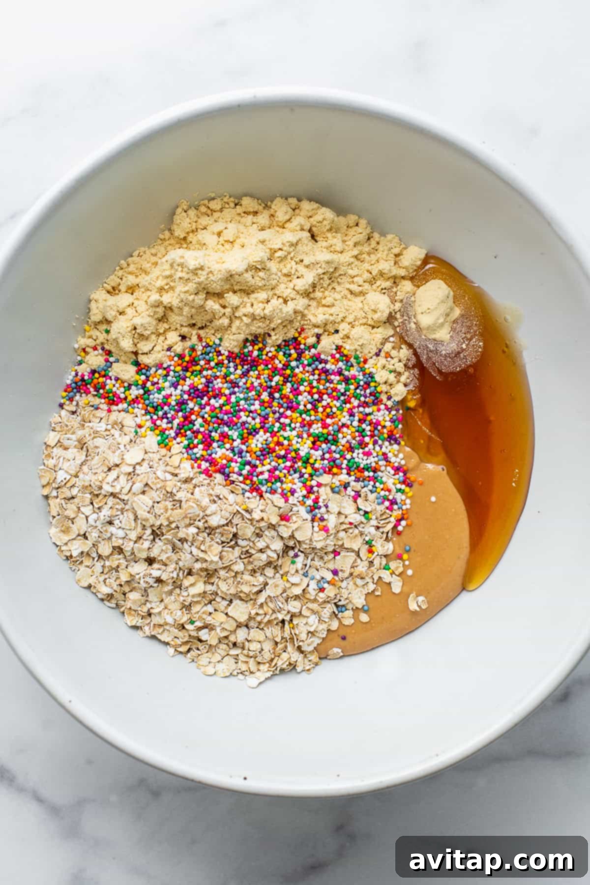 Close-up of protein cake pop ingredients mixed in a bowl, showing a creamy texture.