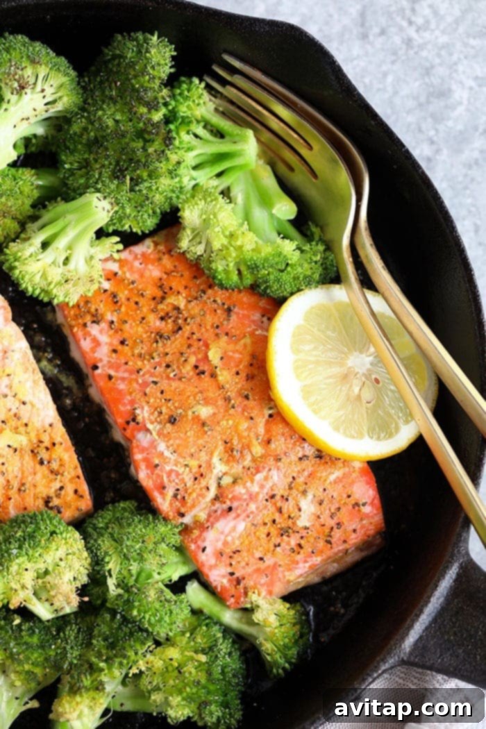 A single, perfectly baked lemon pepper salmon fillet, showcasing its flaky texture and golden crust.