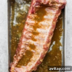 A rib in a pan with marinade.