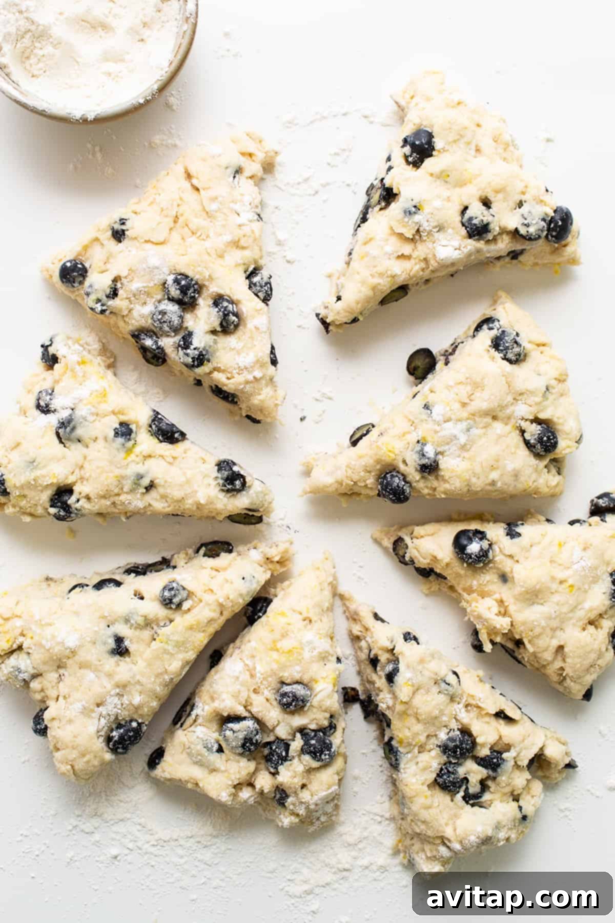 A white plate presents a stack of baked blueberry scones alongside a glass of milk, inviting a delightful snack.