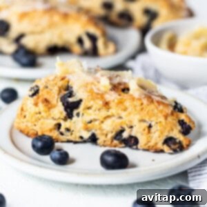 A close-up of a plate filled with beautifully baked lemon blueberry scones, showcasing their golden crust and juicy berries.