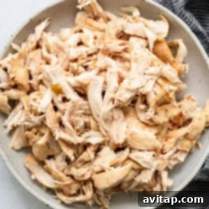 Shredded chicken in a bowl next to a napkin.