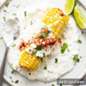 Air fryer elote on a plate, garnished with fresh cilantro.
