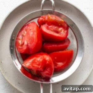 ripe tomatoes in a metal strainer.