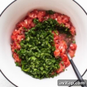 a bowl with tomatoes and herbs in it.