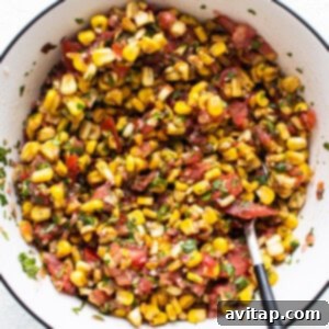 corn salsa in a white bowl with a fork.