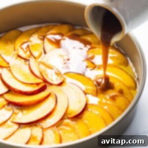 Golden Peach Upside Down Cake 9 A person pouring caramel over a peach tart in a pan.