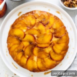 Golden Peach Upside Down Cake 12 A freshly flipped peach upside down cake on a white plate, ready for garnishing.