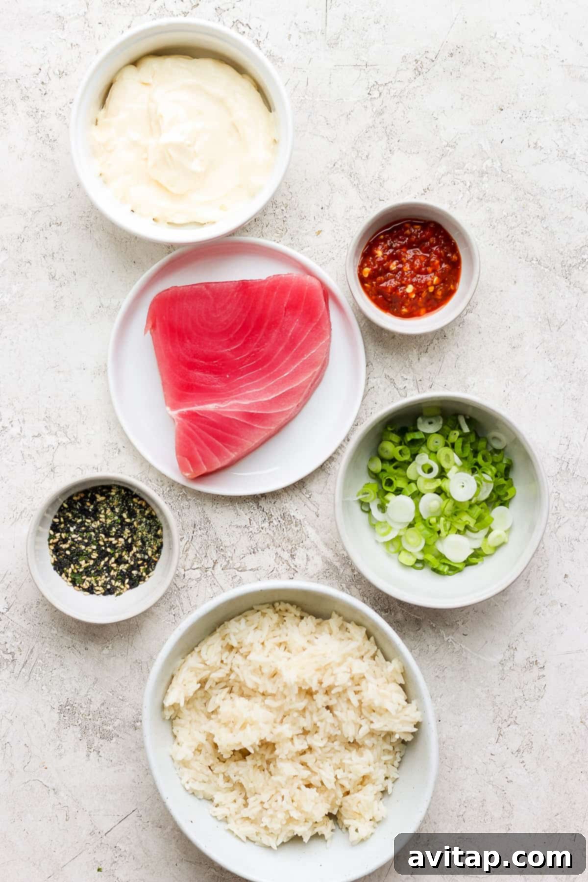 A vibrant selection of fresh ingredients laid out for making spicy tuna rolls.