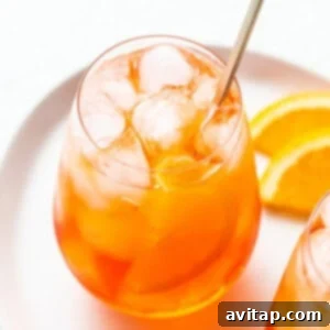 Aperol spritz in a glass with a straw.