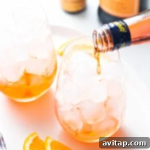 Aperol being poured into a glass for aperol spritz.