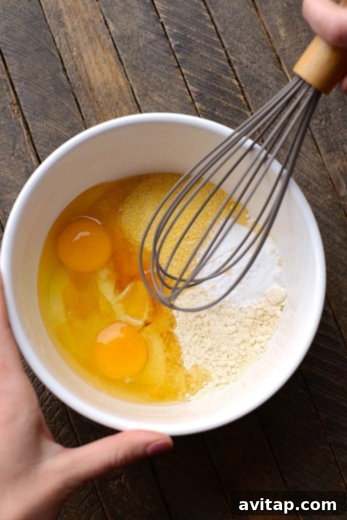 Close-up shot of whole wheat cornmeal pancake batter in a mixing bowl, showcasing its rich texture before cooking.