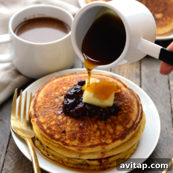 A stack of golden brown whole wheat cornmeal pancakes, ready to be served.