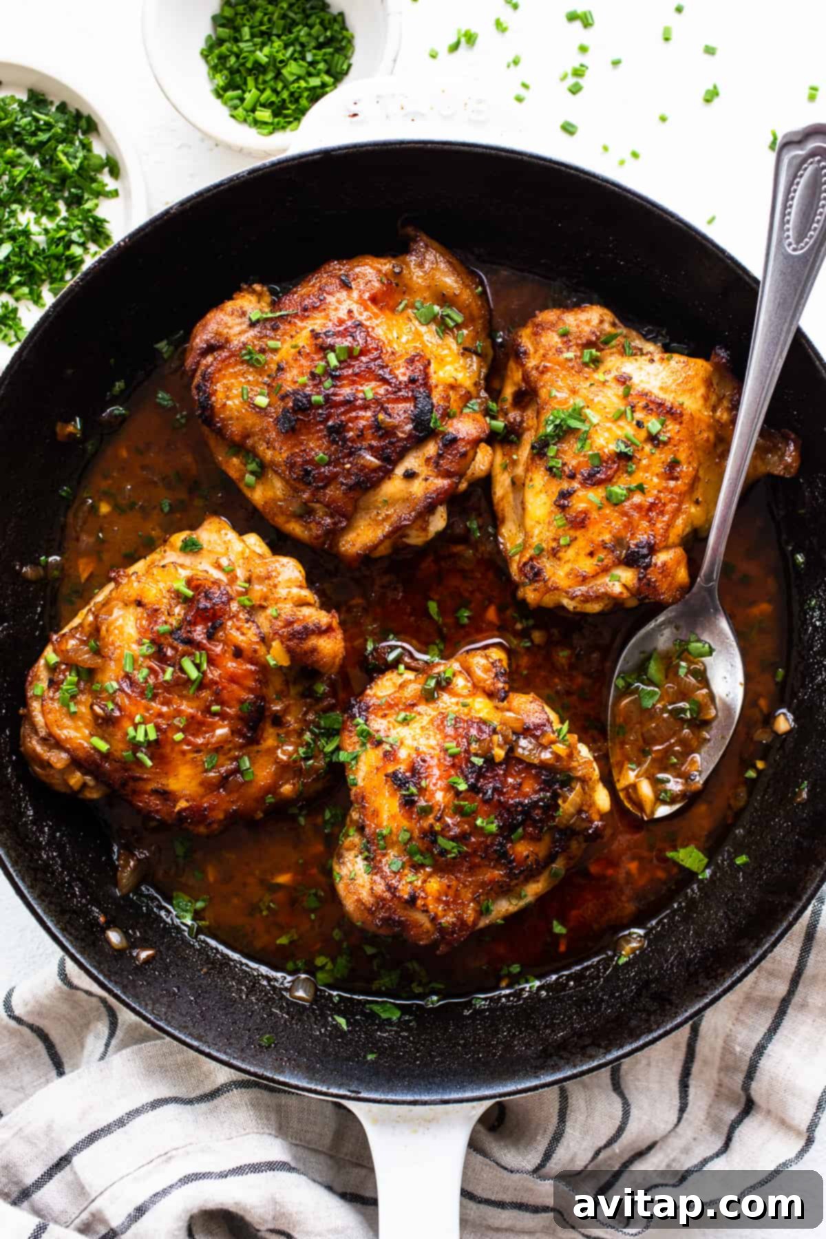 Perfectly Seared Cast Iron Chicken Thighs 2 Perfectly seared crispy cast iron chicken thighs with fresh herbs, ready to be served.