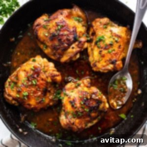 Perfectly Seared Cast Iron Chicken Thighs 12 Chicken thighs in a cast iron skillet with a rich sauce and fresh herbs, ready to be served.